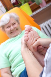 female Nurse massaging foot of a patient